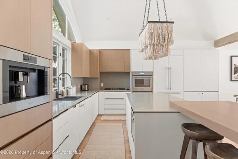 a kitchen that has a lot of cabinets and wooden floor
