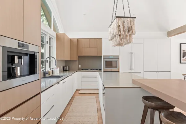 a kitchen that has a lot of cabinets and wooden floor