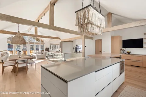 a kitchen with a stove a counter space a large window and living room view