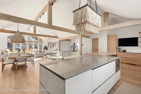 a kitchen with a stove a counter space a large window and living room view