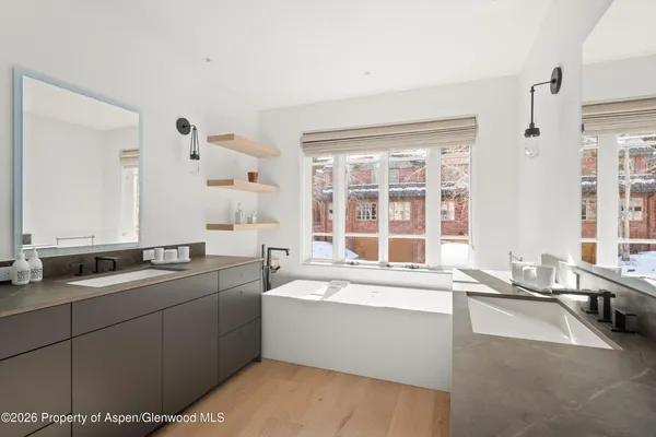 a bathroom with a double vanity sink mirror and shower
