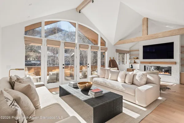 a living room with furniture a flat screen tv and a large window
