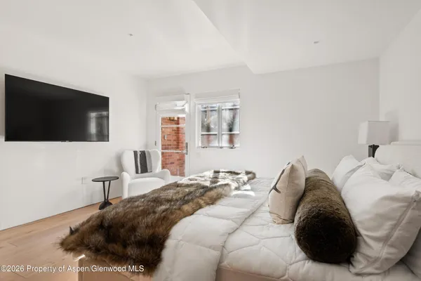 a bedroom with a bed a couch and a flat screen tv