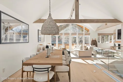 a dining room with furniture a large window and a chandelier