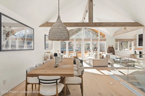 a dining room with furniture a large window and a chandelier