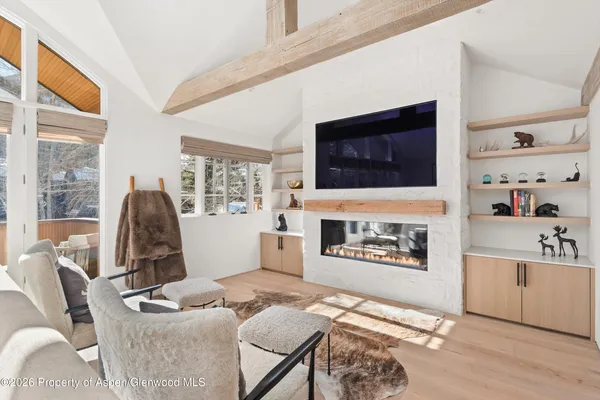 a living room with furniture a flat screen tv and a fireplace
