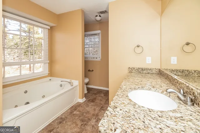 a bathroom with a tub a sink and a large mirror