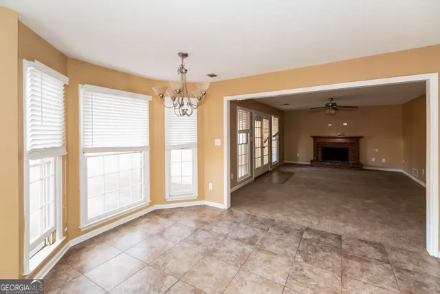a view of an empty room with a fireplace and a window