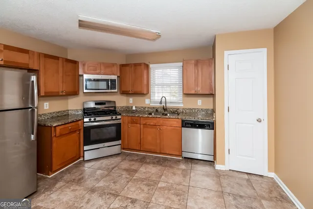 a kitchen with a refrigerator stove top oven and sink