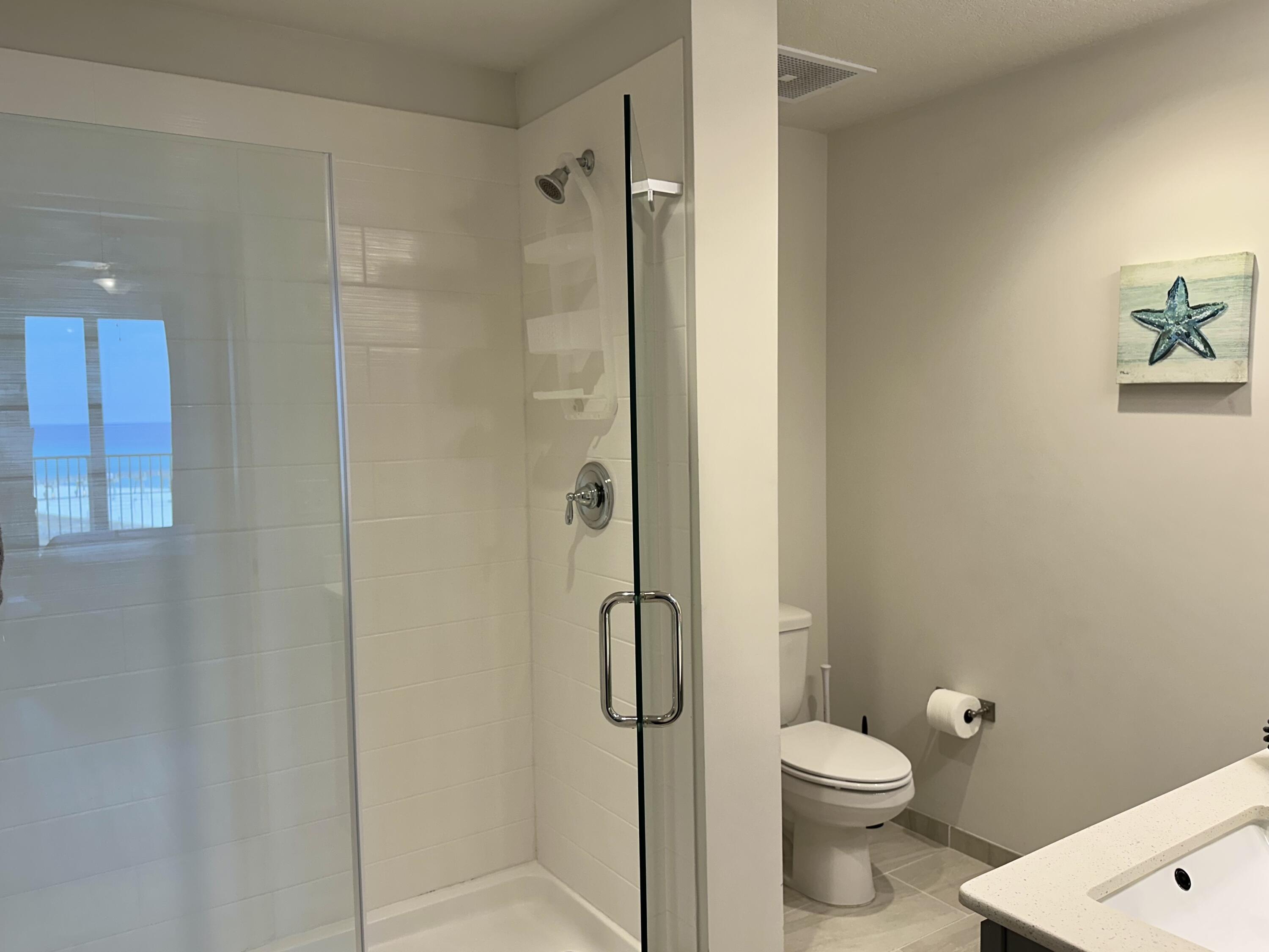 15928 Front Beach Road, Unit 3702 Panama City Beach, FL 32413 - Photo 27 of 85 a bathroom with a granite countertop toilet and a shower