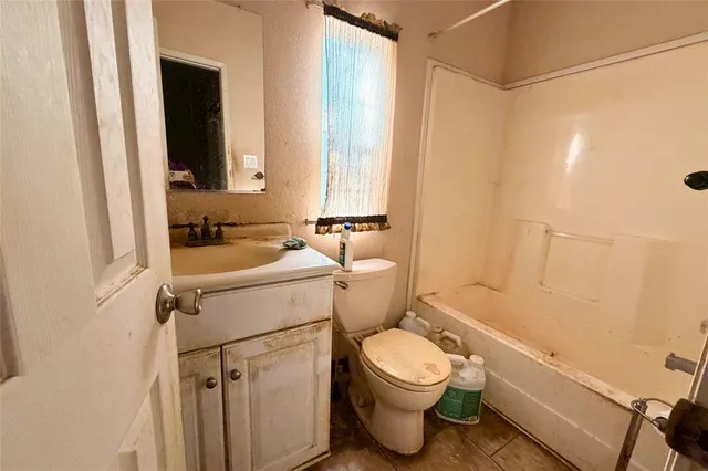 a view of a hallway with wooden floor and a bathroom