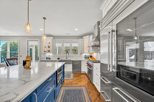 a view of a patio with couches chairs pool and wooden floor
