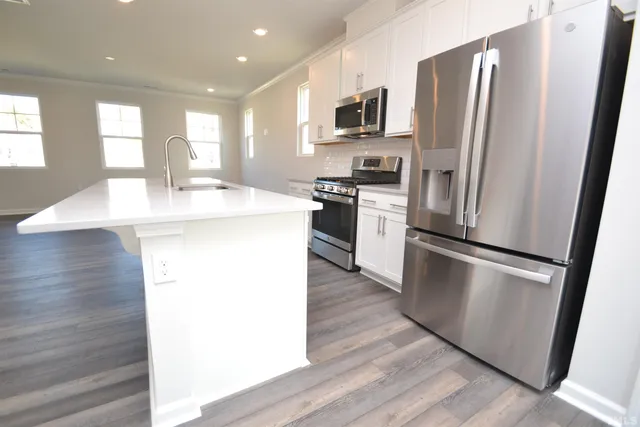a kitchen with stainless steel appliances a refrigerator sink and microwave