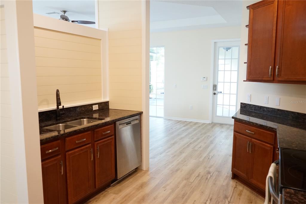201 Sunset Crest Court Apollo Beach, FL 33572 - Photo 11 of 81 a kitchen with granite countertop wooden cabinets and a wooden floor
