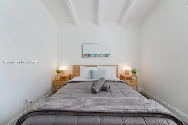 a bed sitting in a bedroom next to a lamp