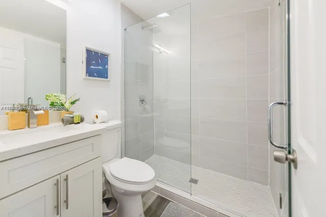 a bathroom with a sink a toilet and shower