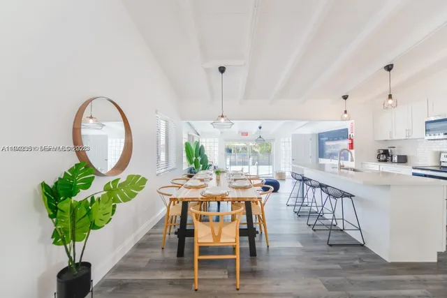 a dining room with furniture a potted plant and a painting