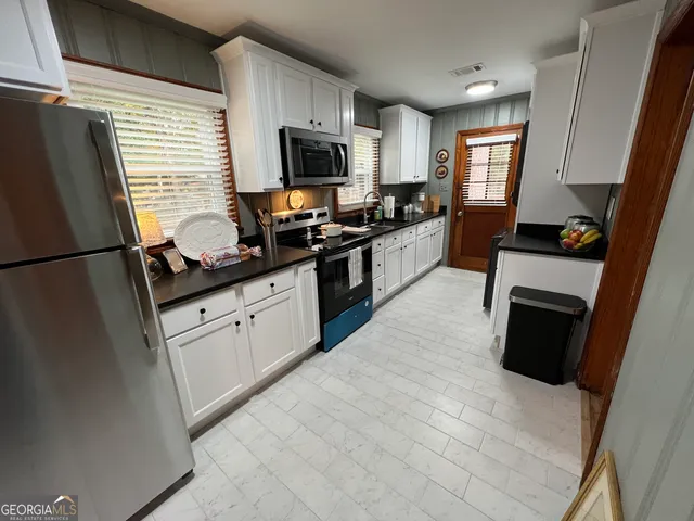a kitchen with granite countertop a sink and a refrigerator