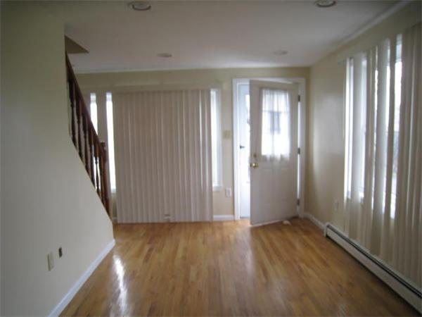 95 Bay Road, Unit A Revere, MA 02151 - Photo 4 of 12 an empty room with wooden floor and windows