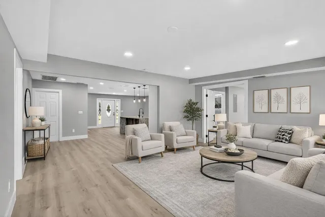 a view of an empty room with wooden floor and windows