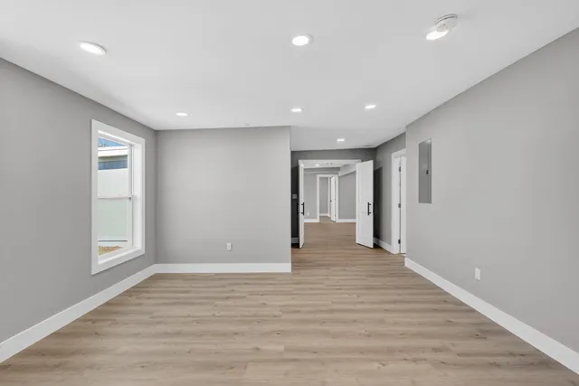 a view of a hallway with wooden floor and staircase