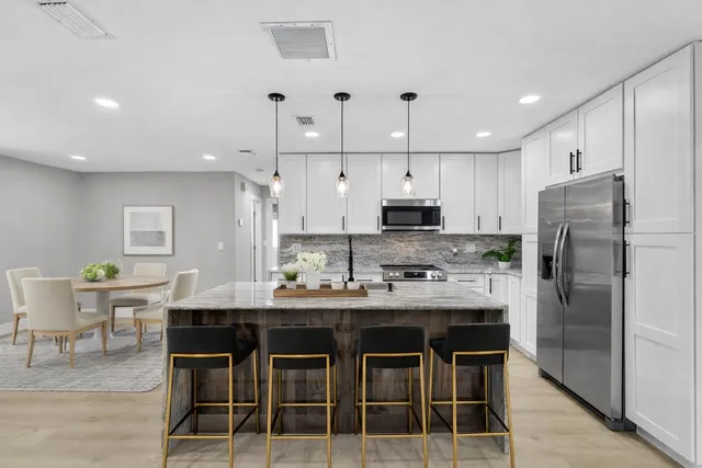 a kitchen with a refrigerator a sink and wooden floor