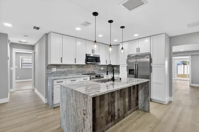 a kitchen with stainless steel appliances granite countertop a sink stove and refrigerator