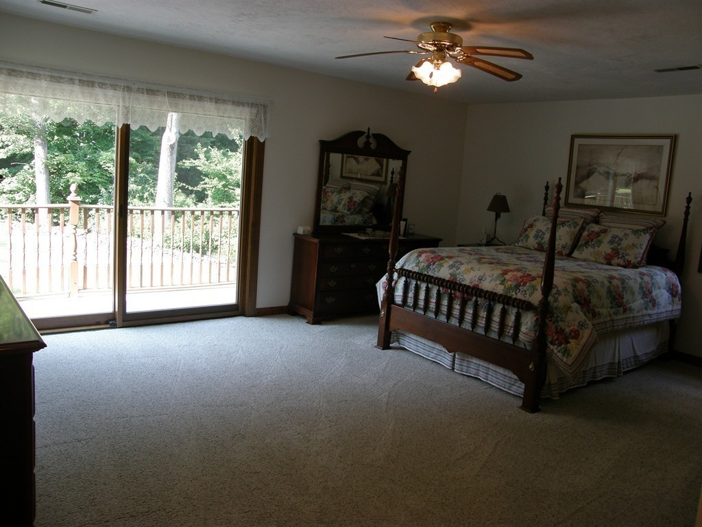 5 Corbin Road Dudley, MA 01571 - Photo 15 of 30 a spacious bedroom with a bed painting on wall and a large window