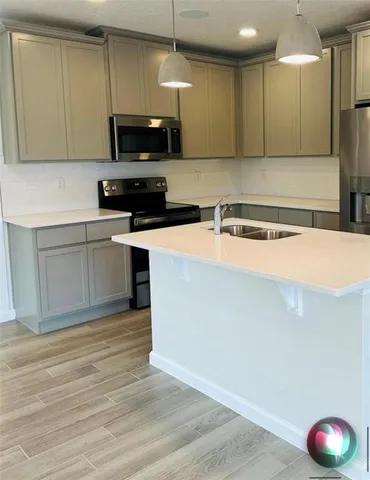 a kitchen with stainless steel appliances granite countertop a stove a sink and a microwave