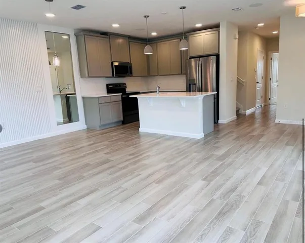 a kitchen with stainless steel appliances kitchen island granite countertop a refrigerator and a stove top oven