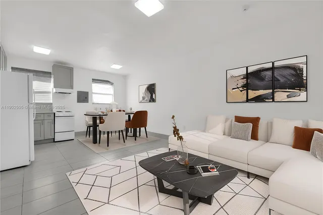 a living room with furniture and a dining table with kitchen view