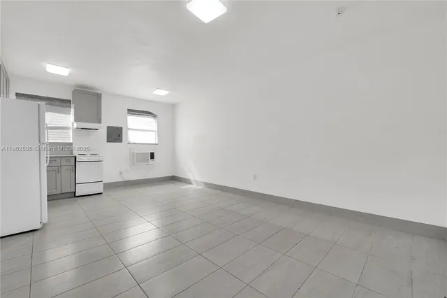 a view of a kitchen with refrigerator and white cabinets