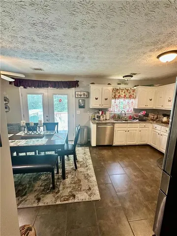 a kitchen with stainless steel appliances granite countertop a stove granite counter tops and white cabinets