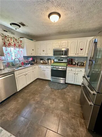 a kitchen with a sink appliances and cabinets