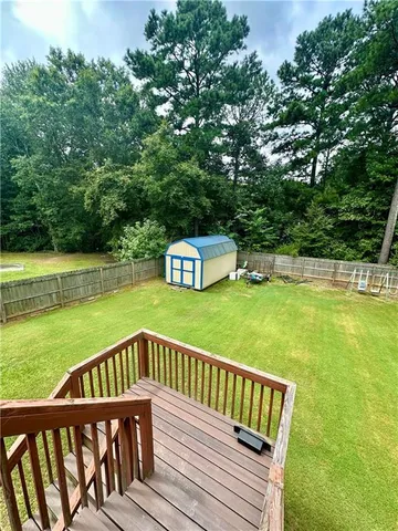 a view of a wooden deck and a yard with swimming pool