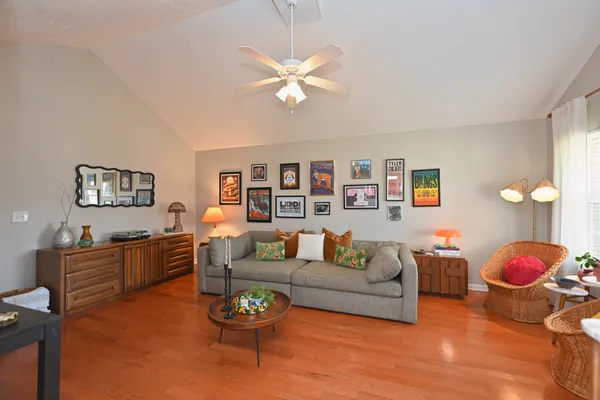 a living room with furniture a chandelier and a wooden floor