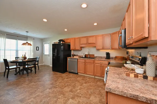a kitchen with granite countertop stainless steel appliances a refrigerator sink and microwave