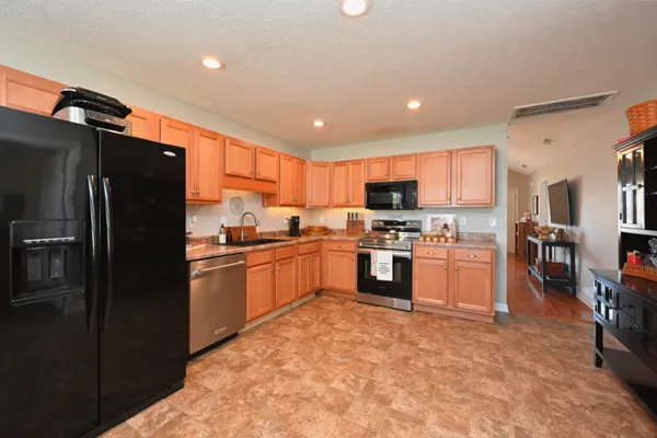 a kitchen with stainless steel appliances granite countertop a sink stove and microwave