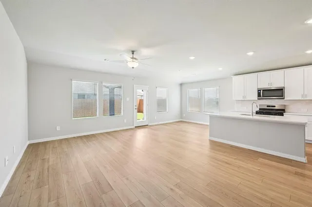a view of a kitchen with wooden floor and electronic appliances