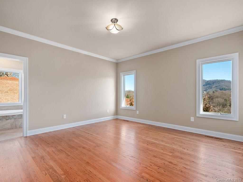 28 Jasper Ridge Clyde, NC 28721 - Photo 16 of 24 a view of an empty room with a window and wooden floor