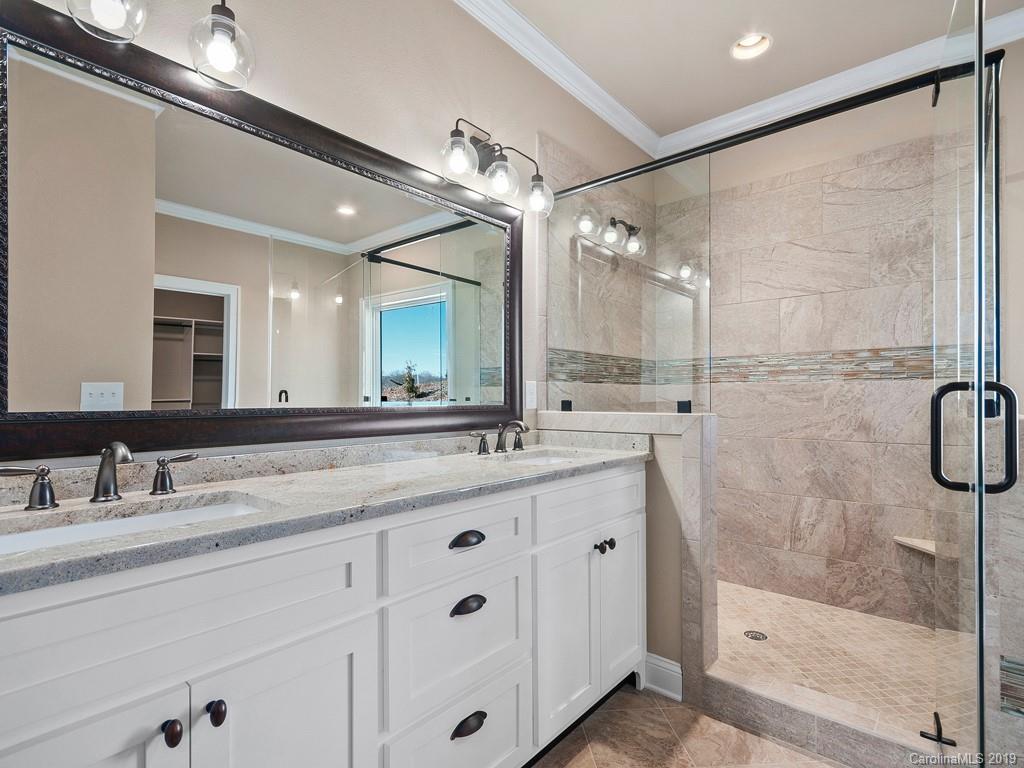 28 Jasper Ridge Clyde, NC 28721 - Photo 20 of 24 a bathroom with a granite countertop sink mirror and a shower