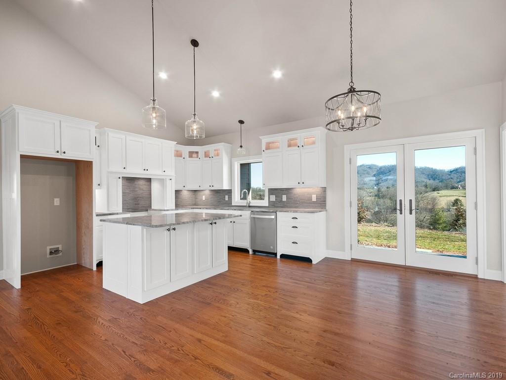 28 Jasper Ridge Clyde, NC 28721 - Photo 6 of 24 a large kitchen with white cabinets and wooden floor