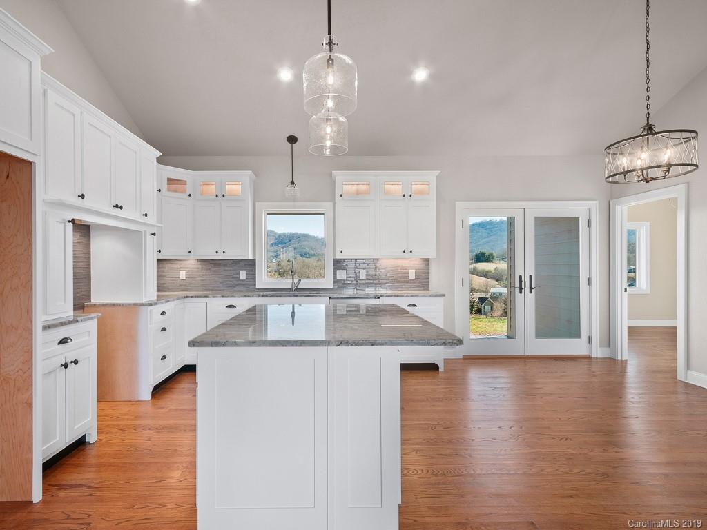 28 Jasper Ridge Clyde, NC 28721 - Photo 7 of 24 a large kitchen with stainless steel appliances kitchen island granite countertop a stove a sink a refrigerator and a dining table with wooden floor