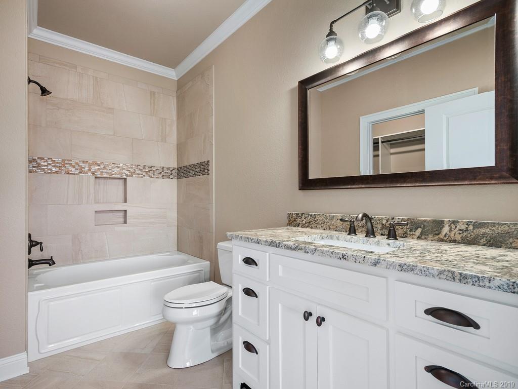 28 Jasper Ridge Clyde, NC 28721 - Photo 10 of 24 a bathroom with a toilet a sink a tub and mirror