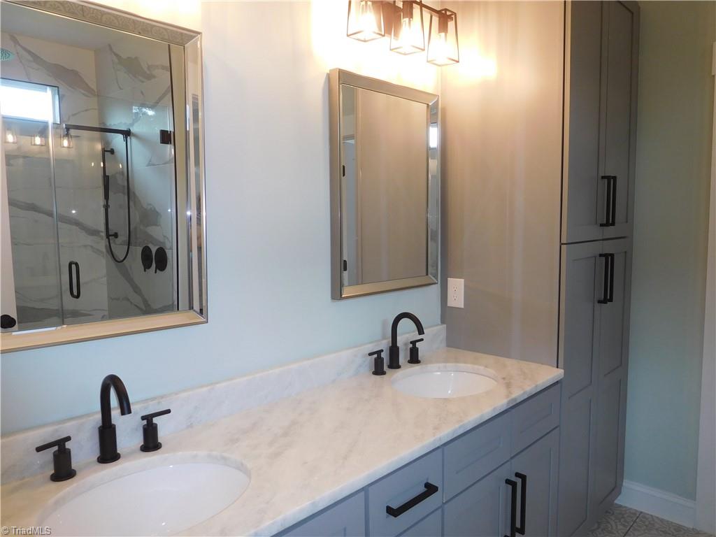7805 Grapevine Road Lewisville, NC 27023 - Photo 27 of 45 BEAUTIFUL PRIMARY EN-SUITE. DOUBLE SINK VANITIES, LINEN STORAGE, QUARTZ TOPS.