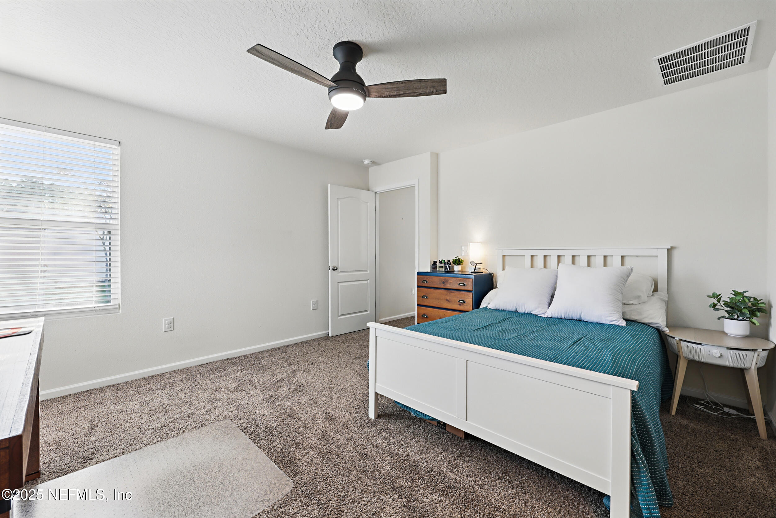 8328 Cape Fox Drive Jacksonville, FL 32222 - Photo 18 of 34 a bedroom with a bed and a chandelier