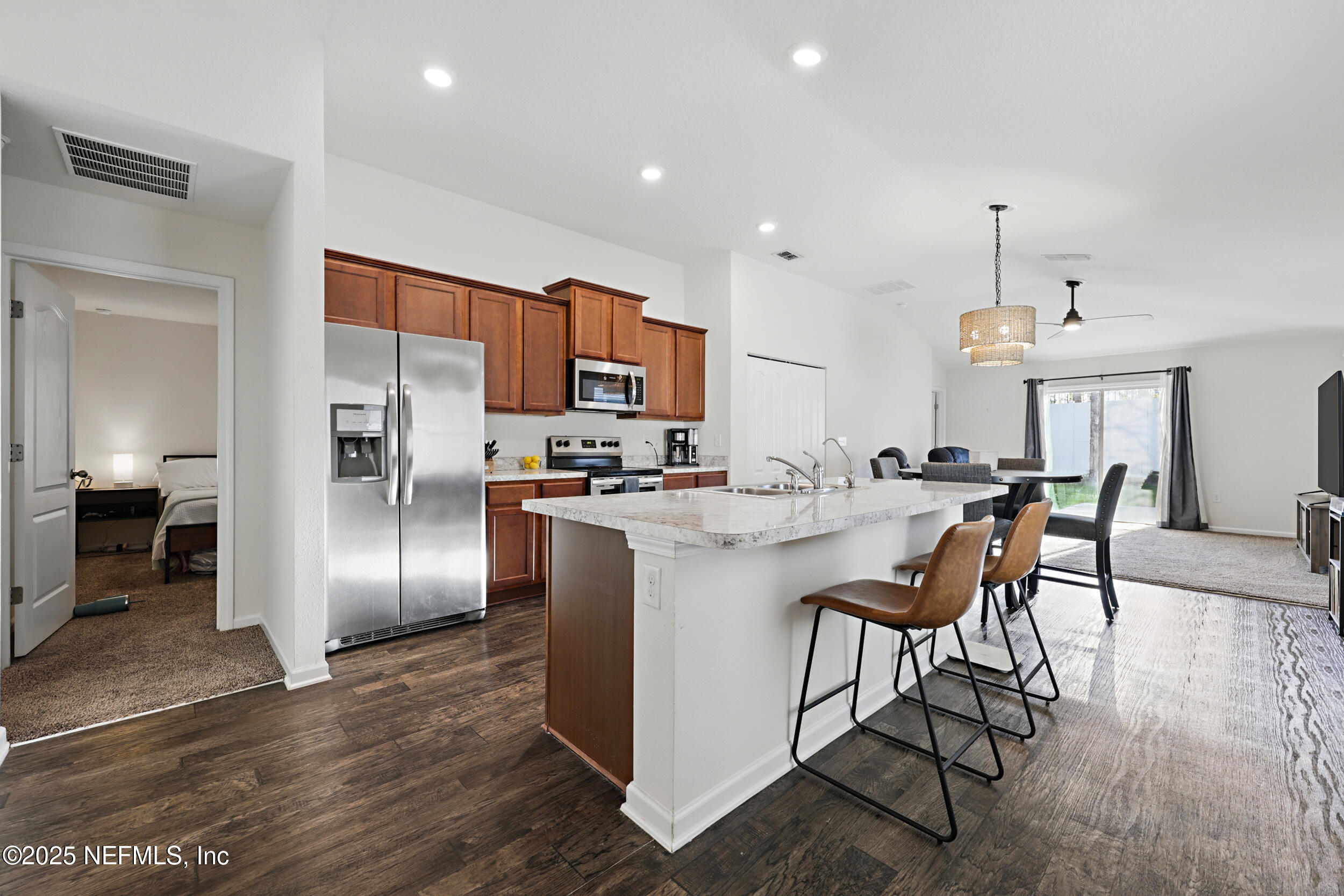 8328 Cape Fox Drive Jacksonville, FL 32222 - Photo 7 of 34 a kitchen with stainless steel appliances kitchen island a refrigerator sink and cabinets