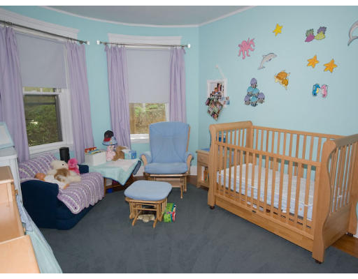 16 Claflin Road, Unit 2 Brookline, MA 02445 - Photo 9 of 10 a living room with furniture and a baby crib with wooden floor