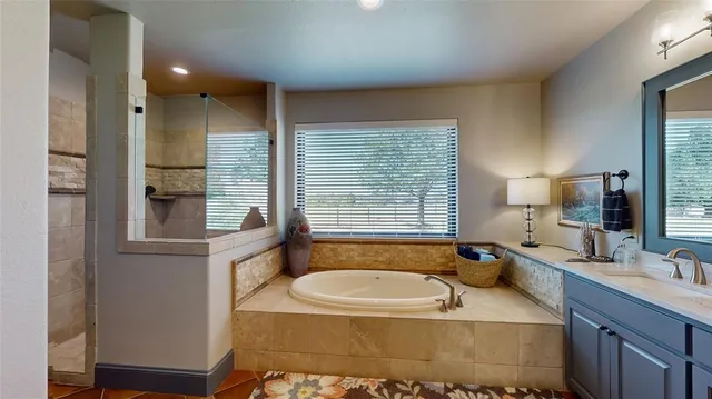 a bathroom with a tub sink and mirror