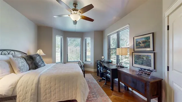 a bedroom with a bed a chandelier and a large window